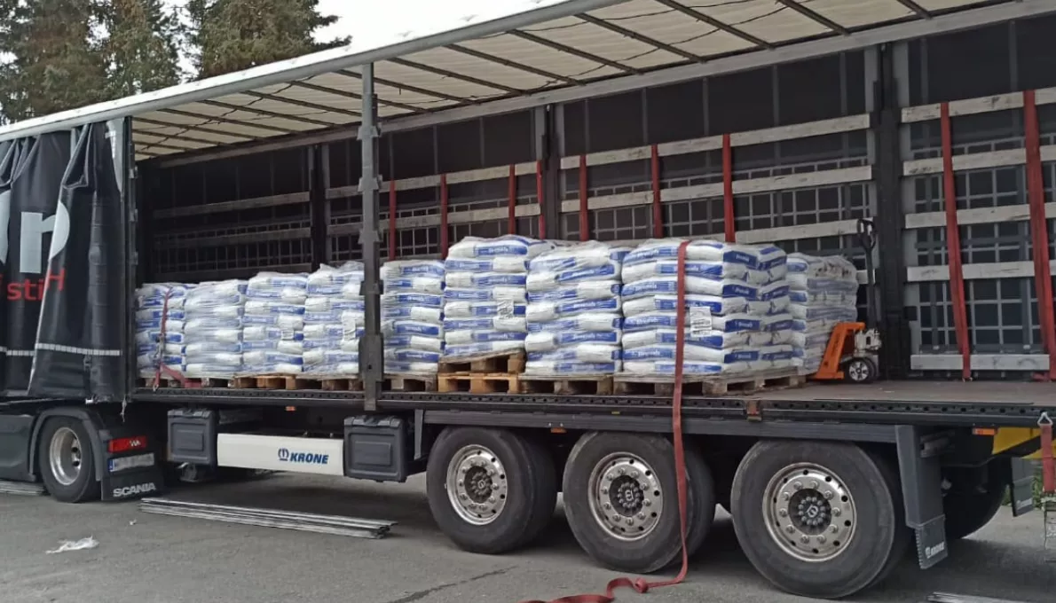 Lkw mit geöffneter Plane, beladen mit palettierten Baustoff-Säcken – Baumaterialien als B-Ware zum Ankauf