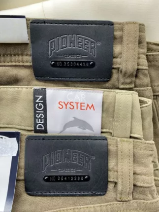 Beige Herren-Hosen der Marke Pioneer mit Lederpatch und Seriennummer am Bund, Nahaufnahme