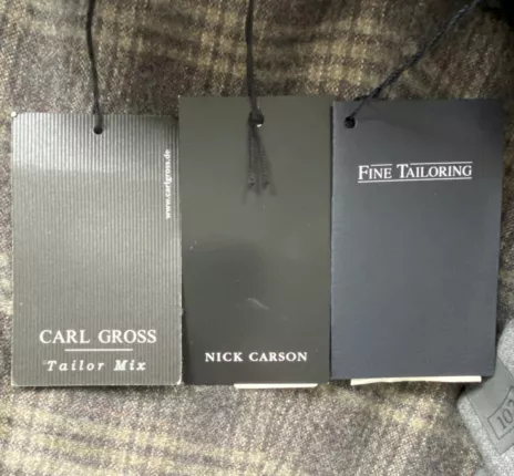 Marken-Anhänger von Carl Gross, Nick Carson und Fine Tailoring an braun gemusterten Herren-Hosen