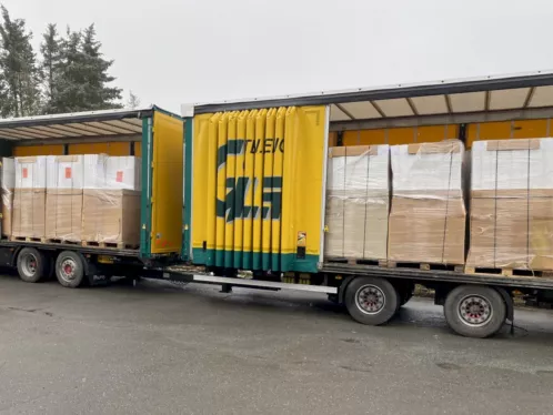 Anlieferung der Duschkabinen aus Geschäftsauflösung: zwei beladene Lkw mit palettierter Ware am Lager