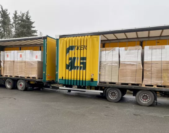 Anlieferung der Duschkabinen aus Geschäftsauflösung: zwei beladene Lkw mit palettierter Ware am Lager