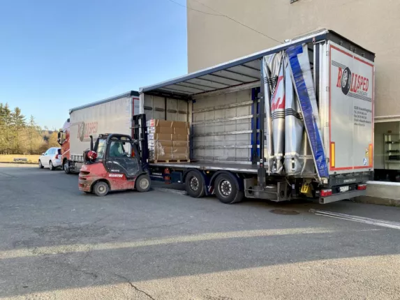 Gabelstapler entlädt verpackte Fahrzeugteile