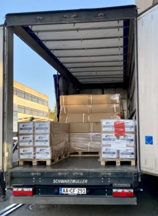 Offene Lkw-Ladefläche mit zwei folierten Paletten voller Kartons mit Offroad- und SUV-Teilen