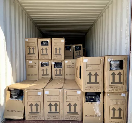 Kartons mit Elektroscootern aus Geschäftsauflösung im Container