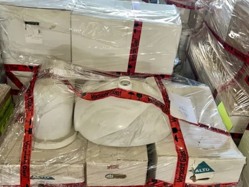 Paletten mit Sanitärkeramik und „Vorsicht Glas“-Bändern