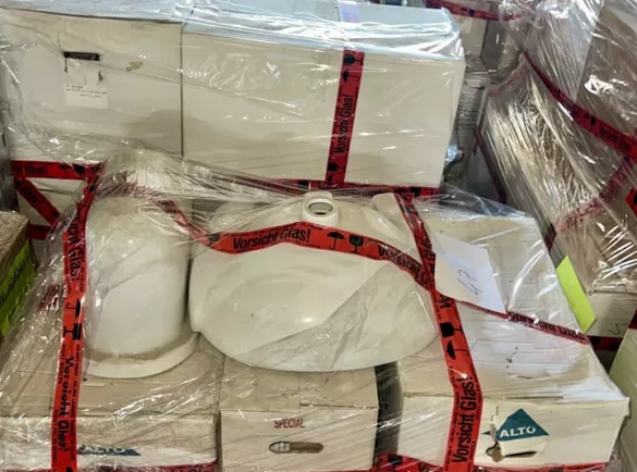 Paletten mit Sanitärkeramik und „Vorsicht Glas“-Bändern