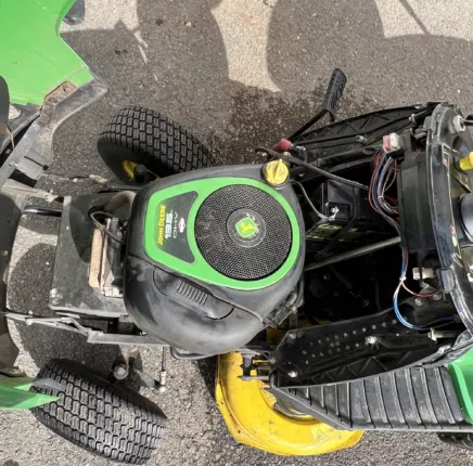 Blick von oben auf Benzinmotor, Batterie und Technik des Aufsitzmähers