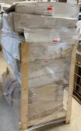 Folienverpackte Kfz-Ersatzteile in Kartons auf einer Palette im Lager