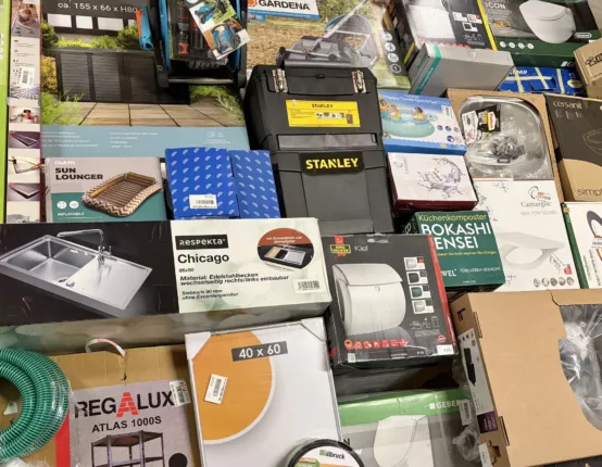 Teils geöffnete Kartons mit gemischter Baumarktware auf einer Palette
