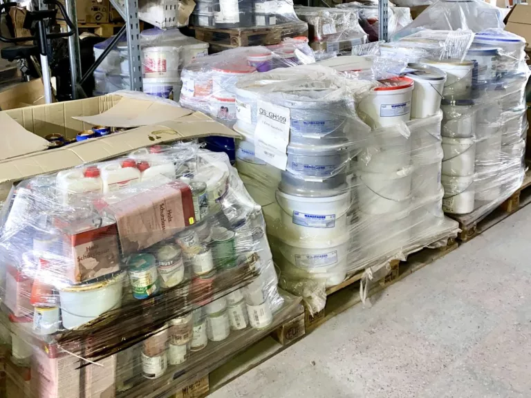 Paletten mit Baumarkt-Restposten – Eimer Wandfarbe, Holz-Schutzlasur und Buntlack in Stretchfolie im Liquidato-Lager