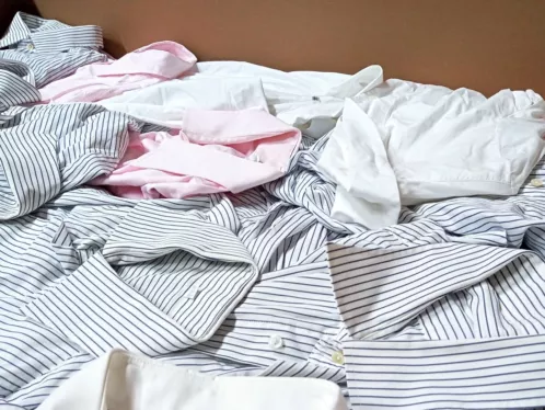 Lose gestapelte Business-Hemden in Weiß, Rosa und blau gestreift — Berufsbekleidung als Kiloware