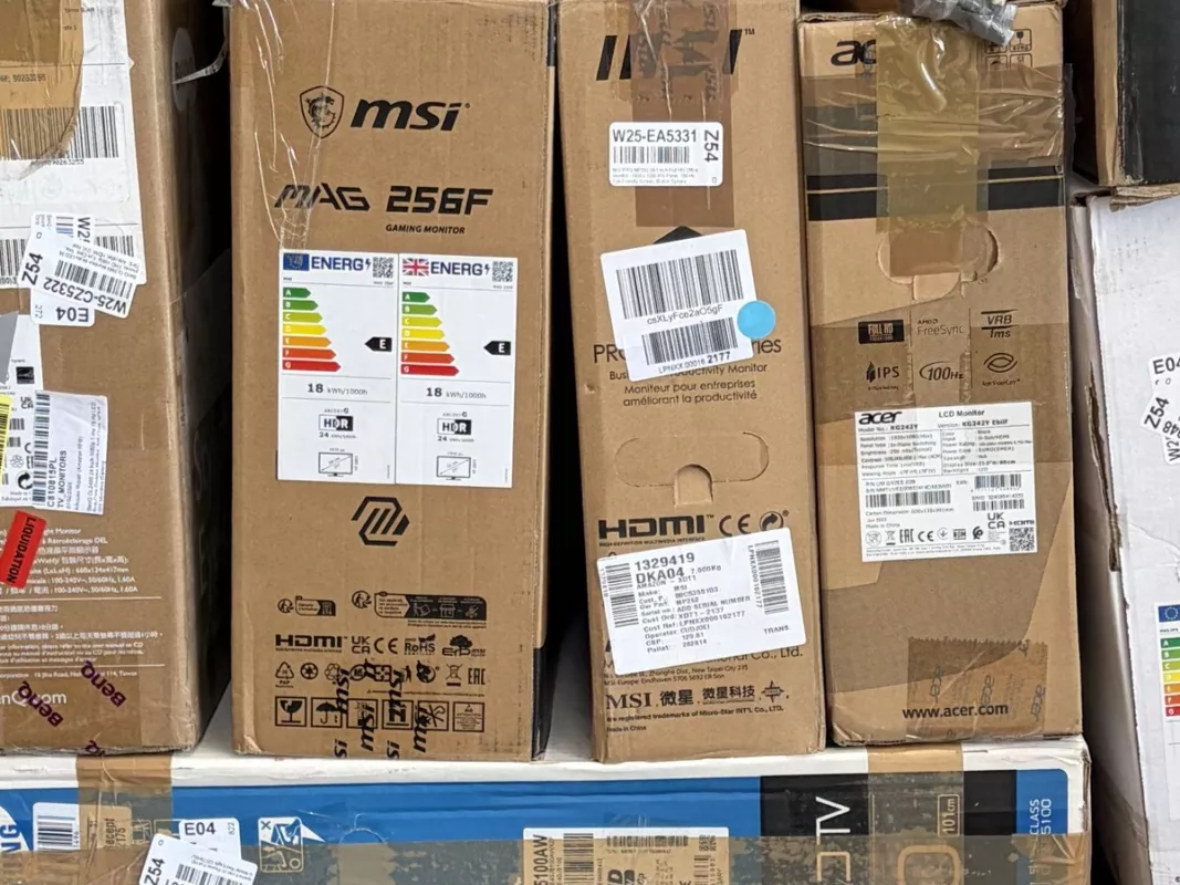 Aufrecht gestapelte Monitor-Restposten (MSI, Acer, Philips, BenQ) als gebrauchte IT-Hardware im Lager von Liquidato