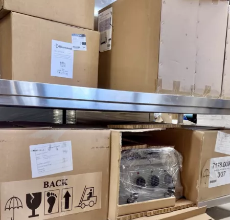 Restposten gewerblicher Elektro-Fritteusen: originalverpackte Kartons und ein geöffneter Karton mit Edelstahl-Fritteuse