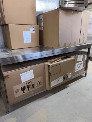 Posten Elektro-Fritteusen für die Gastronomie auf Edelstahltisch, Kartons mit geöffneter Fritteuse