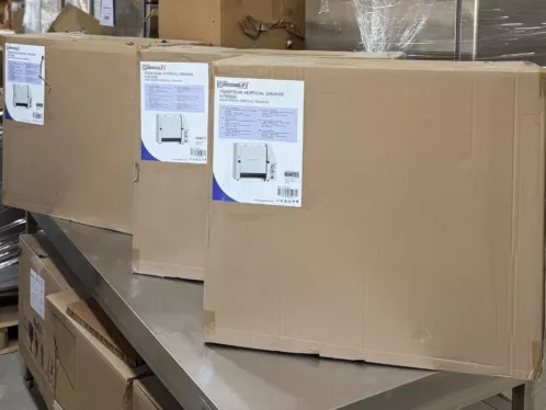Originalverpackte Profi-Gastro-Toaster, gestapelt auf einem Edelstahl-Arbeitstisch im Lager
