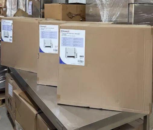 Originalverpackte Profi-Gastro-Toaster, gestapelt auf einem Edelstahl-Arbeitstisch im Lager