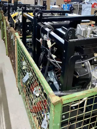 Rahmen-Stromerzeuger mit sichtbarem Motor und Kabelbaum in einer Gitterbox