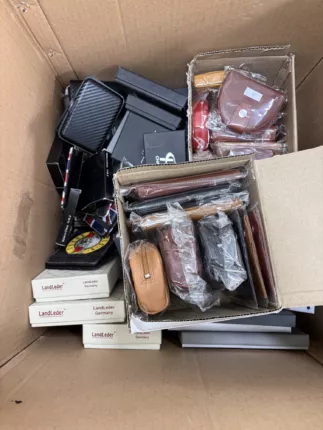 Zwei Kartons mit Kleinlederwaren – Geldbörsen, Münzbörsen und Kartenetuis in Cognac, Rot und Schwarz samt Geschenkboxen