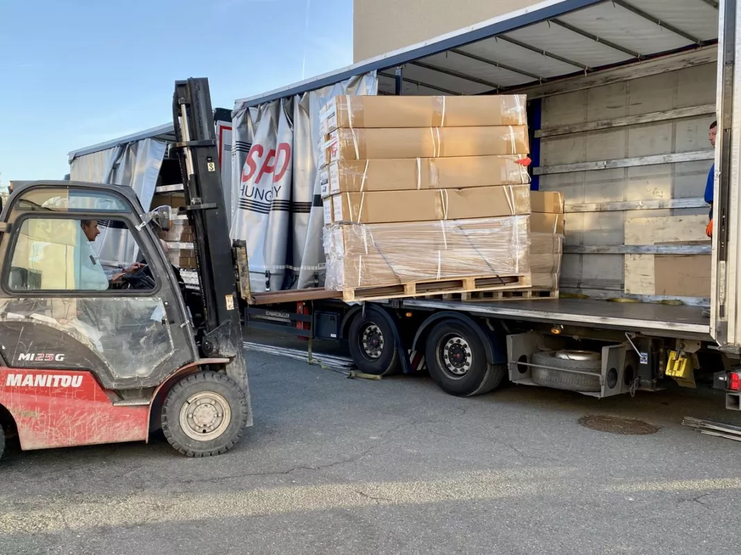 Manitou-Gabelstapler verlädt palettierte Ware auf einen Lkw im Ablauf von Liquidato