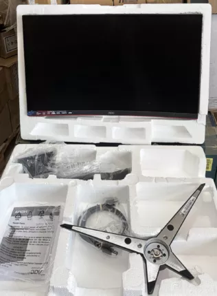 Ausgepackter Curved-Gaming-Monitor in der Styropor-Verpackung mit Standfuß, Kabeln und Kurzanleitung